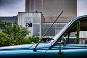 A view on the exterior of Port 58 offices through a vintage car